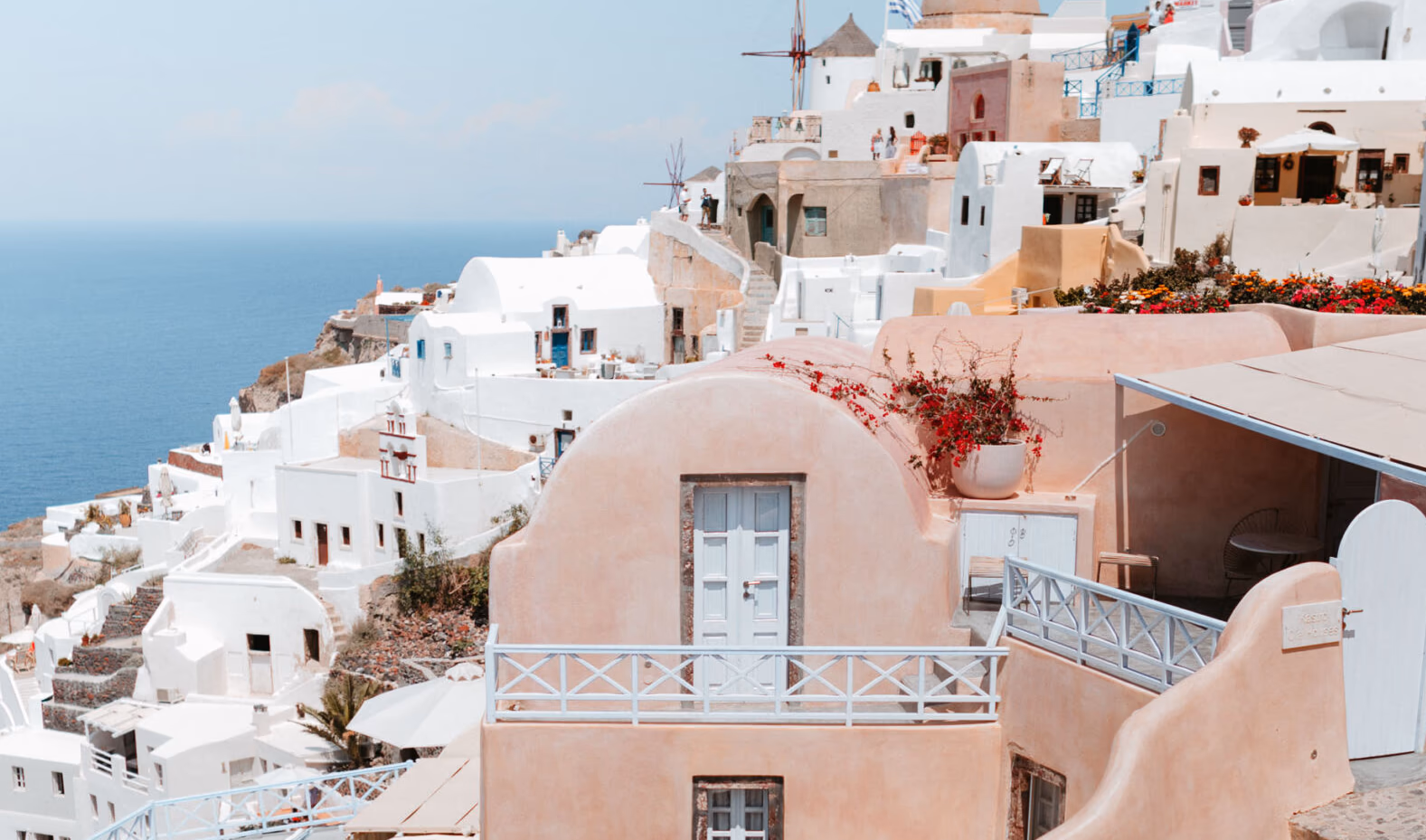 Whitewashed Santorini village with a cliffside windmill overlooking the Aegean